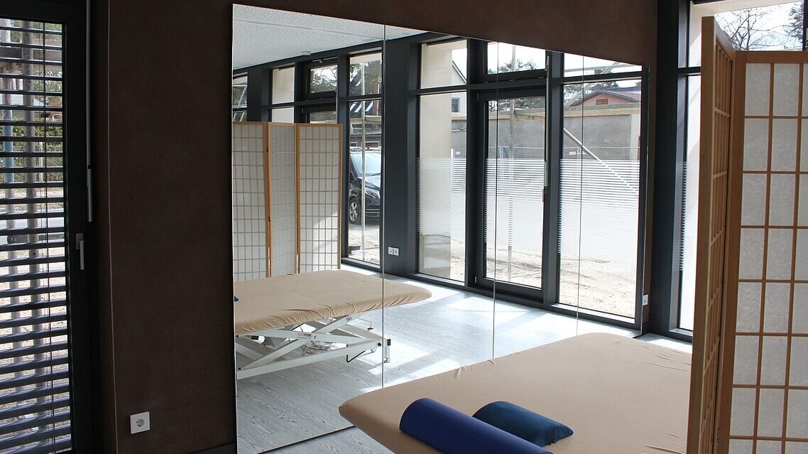 Sportraum mit Spiegelwand und Abtrennung.